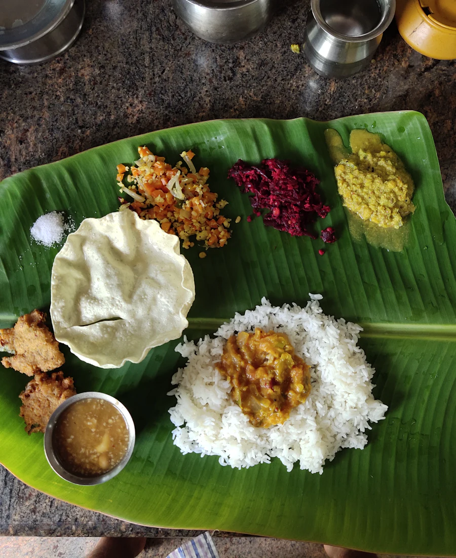A traditional South Indian meal served on a banana leaf with rice, papad and curries