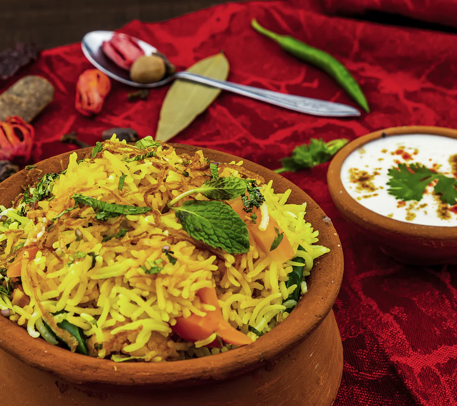 Colourful vegetable pulao served in a clay pot with cooling raita