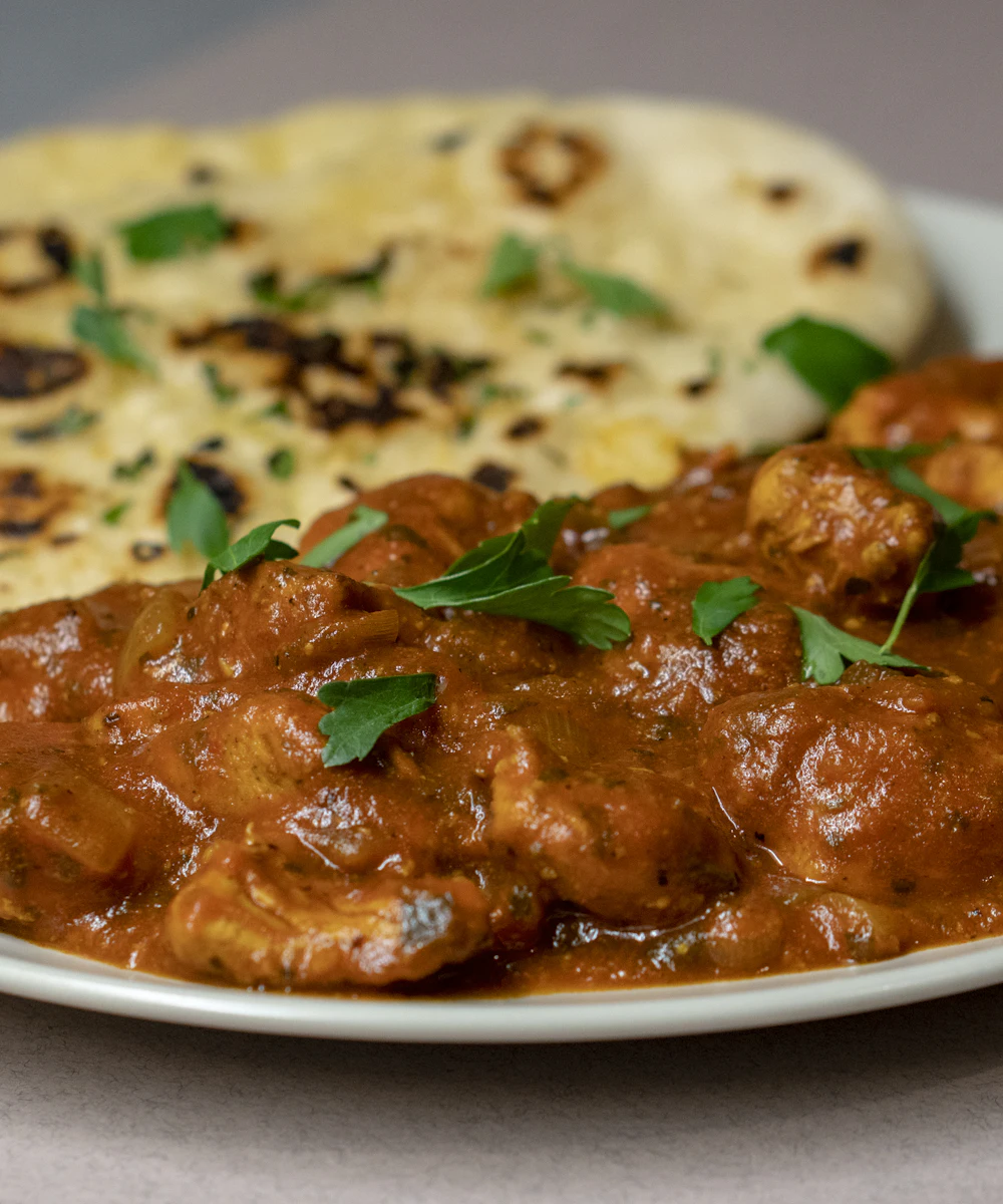 Slow-cooked Indian curry served with soft, freshly made naan